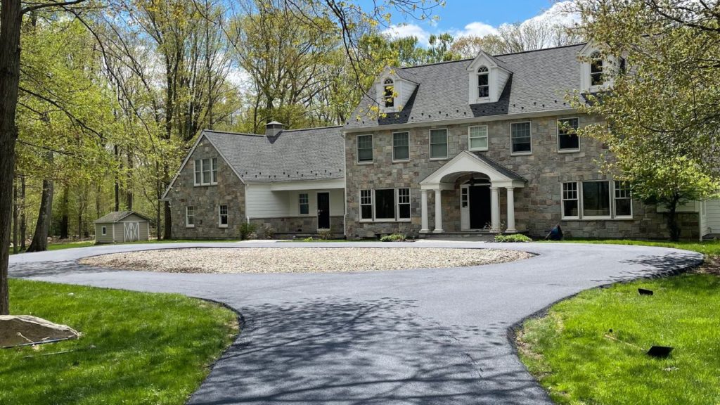 Freshly paved asphalt driveway in front of a New Jersey home