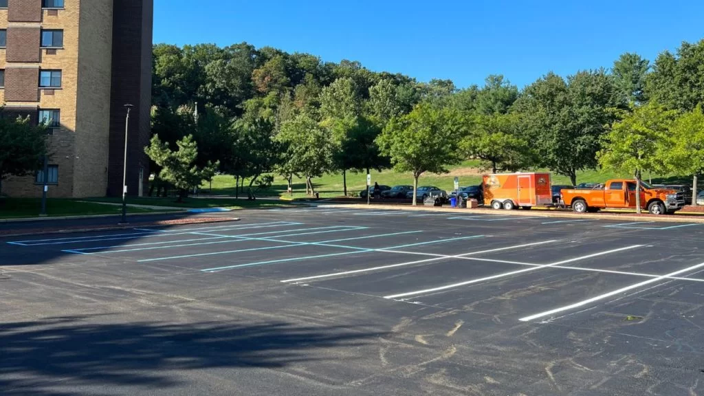 Freshly paved and striped asphalt parking lot with paving equipment in New Jersey